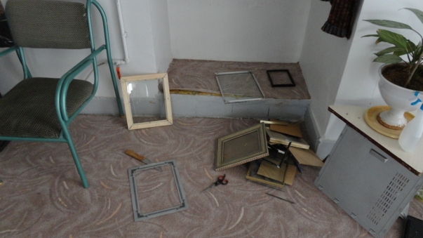 Agenţii guvernului din Iran au confiscat cărţi bahá’í şi CD-uri, calculatoare şi alte obiecte, inclusiv fotografii intr-un raid asupra 14 case bahá’í la Abadeh, Iran, în data de 13 octombrie 2013.  Aici se văd ramele din care au fost rupte fotografii confiscate.